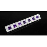 An early to mid 20th century 18ct white gold, amethyst and diamond cluster set bar brooch, 68mm,