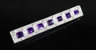 An early to mid 20th century 18ct white gold, amethyst and diamond cluster set bar brooch, 68mm,