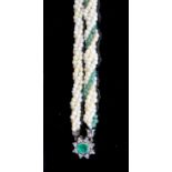 An early 20th century interwoven seed pearl and emerald bead set double strand bracelet, with foil