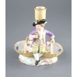A Meissen figural candlestick, 19th century, in the form of a boy seated on a double basket, on