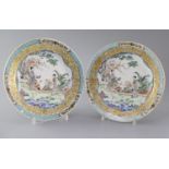 A fine pair of Chinese famille rose plates, Yongzheng period, each painted with two ladies in a