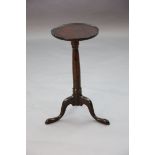 A George II yew wood tripod table with dished circular top and turned stem on a cabriole tripod