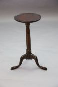 A George II yew wood tripod table with dished circular top and turned stem on a cabriole tripod