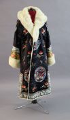 A Chinese silk embroidered winter robe, late 19th century/early 20th century, woven with roundels of