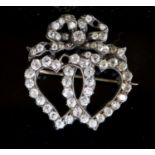 A Victorian gold, silver and diamond cluster set entwined twin hearts brooch, with ribbon bow