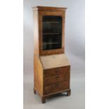 An early 18th century banded walnut bureau bookcase with moulded cornice and single glazed door,