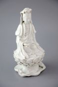 A Chinese Dehua blanc de chine seated figure of Guanyin, 18th/19th century, the figure holding a