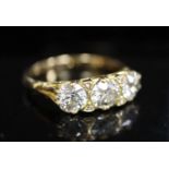 A Victorian style yellow metal and three stone diamond ring with diamond chip spacers, gross 4.5