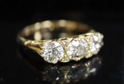 A Victorian style yellow metal and three stone diamond ring with diamond chip spacers, gross 4.5