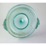 A Roman green glass dish, 1st/2nd century AD, the folded rim applied with a pair of dolphin shaped