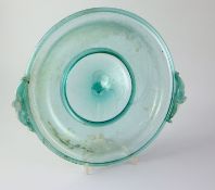 A Roman green glass dish, 1st/2nd century AD, the folded rim applied with a pair of dolphin shaped