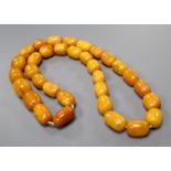 A single strand oval amber bead necklace, 74cm, gross weight 128 grams, largest bead approx. 26mm by