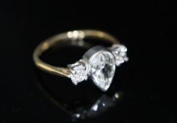 A gold and three stone diamond ring, the central pear cut stone weighing approximately 0.75ct and