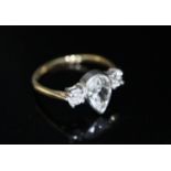 A gold and three stone diamond ring, the central pear cut stone weighing approximately 0.75ct and