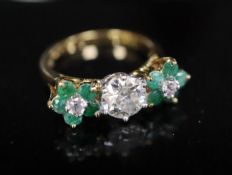 A modern 18k emerald and diamond set dress ring, the central stone weighing approximately 1.00ct,