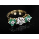 A modern 18k emerald and diamond set dress ring, the central stone weighing approximately 1.00ct,