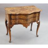 An 18th century Dutch and walnut marquetry lowboy, decorated with flowers in an urn, masks, birds,