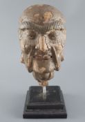 A Chinese clay and wood head of a luohan, possibly Song dynasty, mounted on a later plinth, 29cm