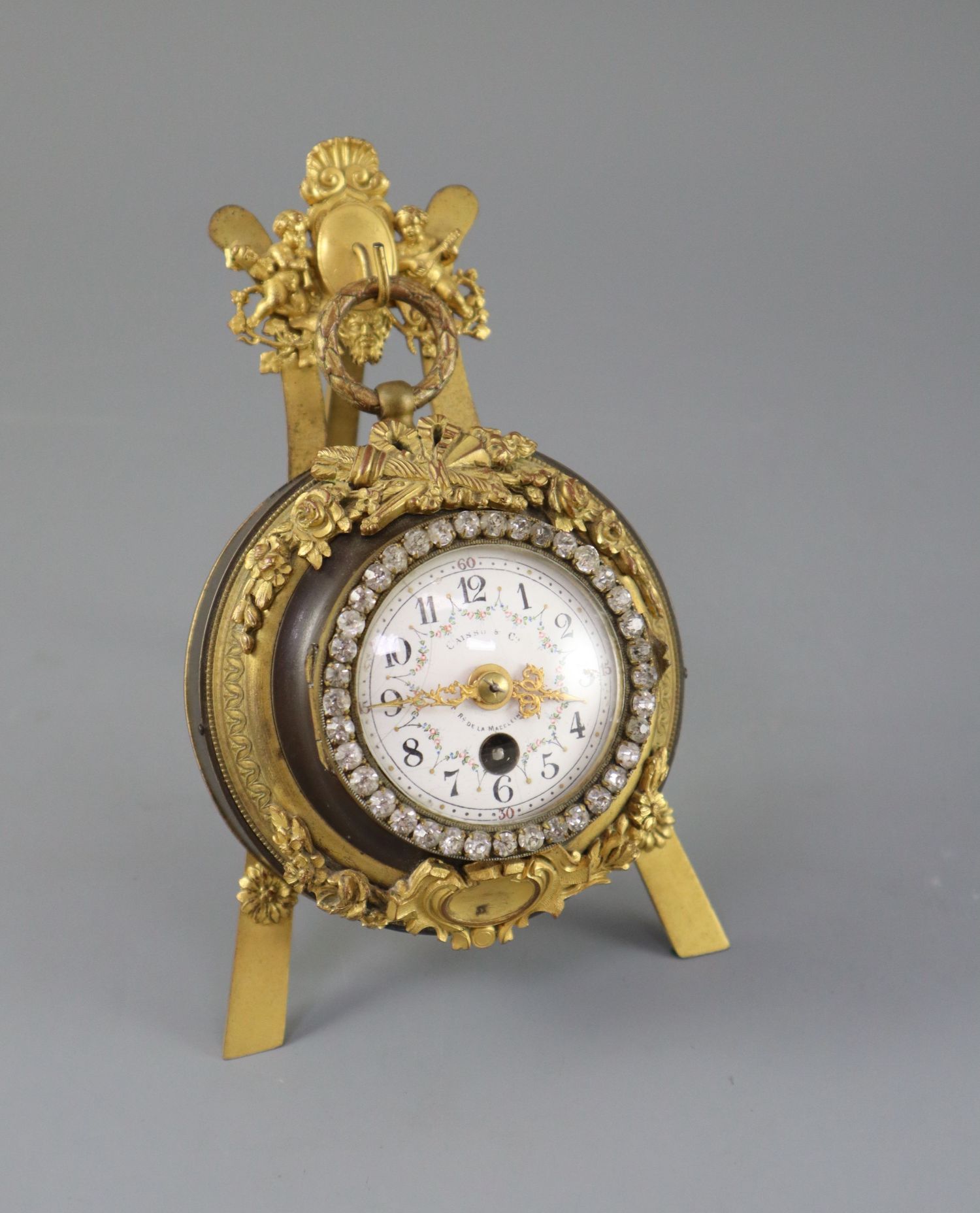 An early 20th century French bronze and ormolu desk timepiece, of cartel clock form resting upon