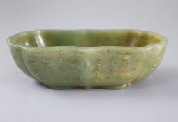 A Chinese inscribed green jade brushwasher, of ruyi outline, with engraved and gilt inscriptions
