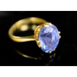 A gold (stamped 24k) and solitaire oval cut Ceylon sapphire set ring, maker's W. Bros, the stone