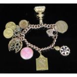 A late 19th/early 20th century 9ct gold curb link charm bracelet, hung with with assorted charms,