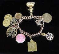 A late 19th/early 20th century 9ct gold curb link charm bracelet, hung with with assorted charms,