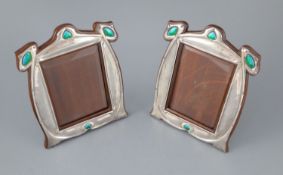 A matched pair of Edwardian Art Nouveau silver and enamel photograph frames, with stylised