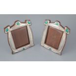 A matched pair of Edwardian Art Nouveau silver and enamel photograph frames, with stylised
