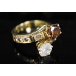 A modern gold and two colour diamond two stone crossover ring, with baguette and round cut diamond