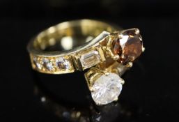 A modern gold and two colour diamond two stone crossover ring, with baguette and round cut diamond