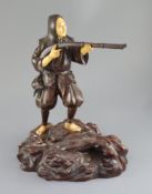 A good Japanese bronze and ivory okimono of a huntsman, Meiji period, the huntsman aiming his musket