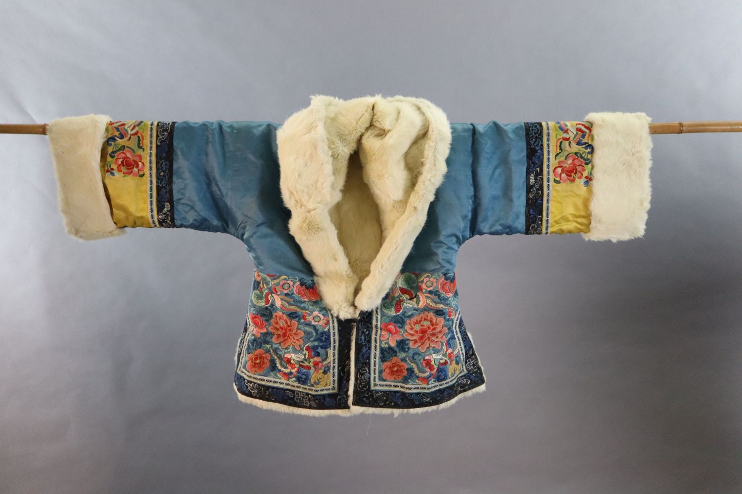 A Chinese embroidered silk winter jacket, late 19th/early 20th century, with white fur lining,