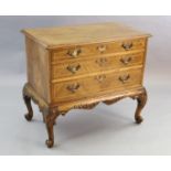 A Georgian style crossbanded walnut chest of three graduated long drawers, with quarter veneered