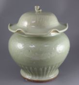 A large Chinese celadon jar and cover, Ming dynasty or later, the lotus leaf shaped cover above a