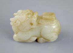 A Chinese pale celadon jade figure of a recumbent qilin, the stone with some russet inclusions, 5.