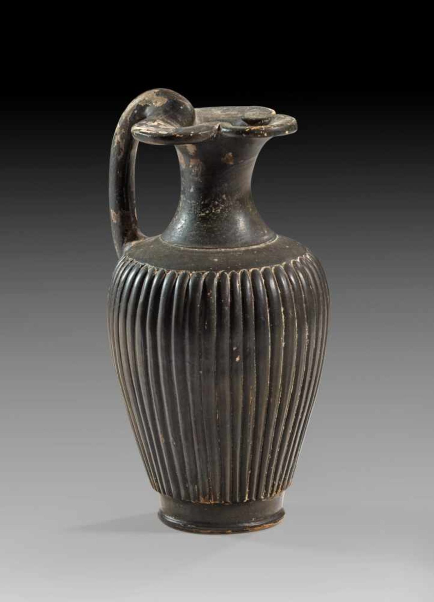 Etruskische Oinochoe. 1. Hälfte 3. Jh. v. Chr. H 19,8cm, ø 10,7cm. Kleeblattkanne mit geripptem