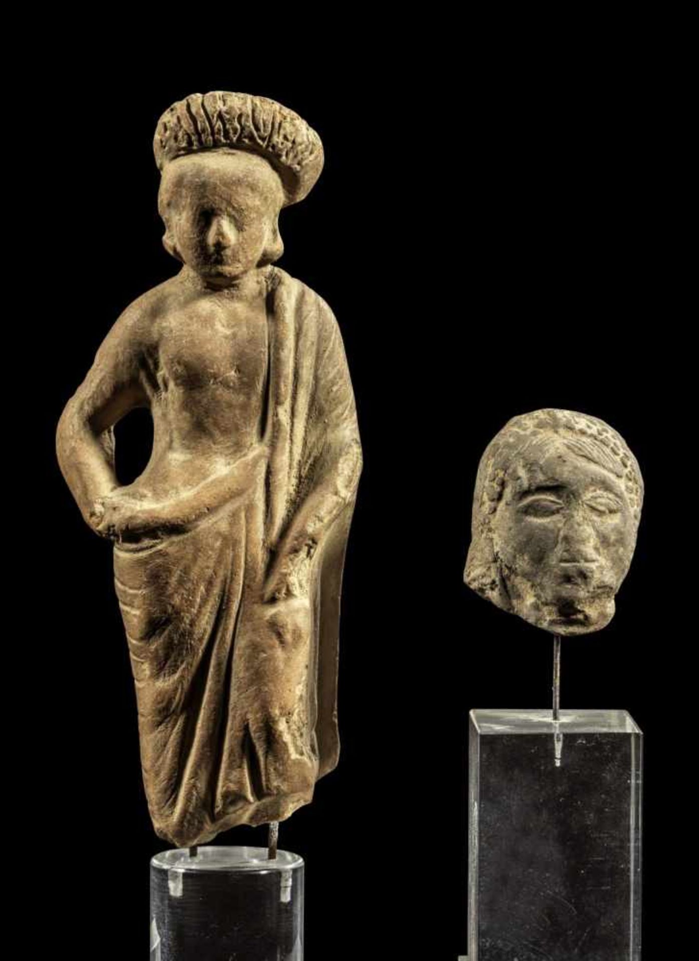 Terrakotta-Figur und ein Kopf. ca. 4. - 3. Jh. v. Chr. a) H ohne Ständer 14,6cm. Ephebe im Mantel