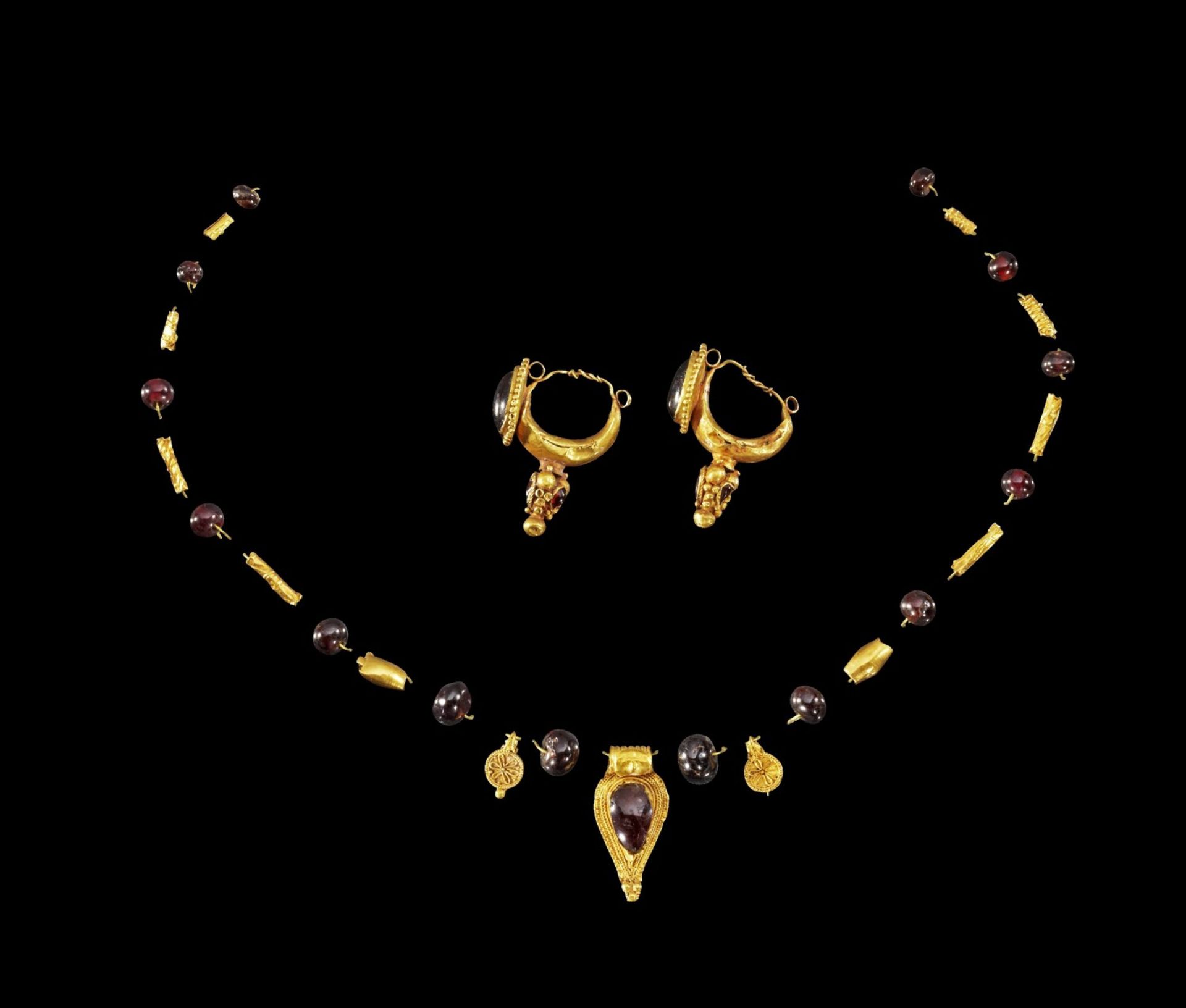 Kettenelemente aus Gold und Granat und ein Paar Ohrringe aus Gold.