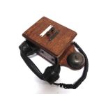 A SIGNAL BOX WALL-MOUNTED TELEPHONE with an oak case and a bakelite handset, 29cm high.