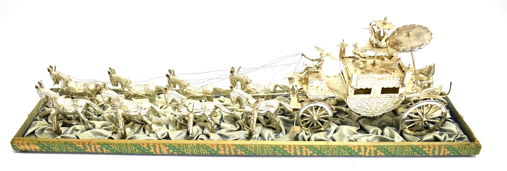 A FAR EASTERN WHITE METAL CARRIAGE PULLED BY EIGHT HORSES WITH ATTENDANTS the embossed carriage