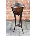 AN EDWARDIAN MAHOGANY JARDINIERE STAND with brass liner, on metal capped feet, 93cm high