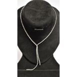 AN 18CT WHITE GOLD DIAMOND LINE NECKLACE With two tassle drop front, comprising a total of 243 round