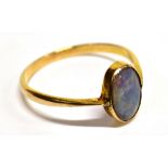 A BLACK OPAL SINGLE STONE YELLOW GOLD RING The old cabochon cut opal 10mm x 7mm, blue green play