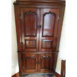 AN OAK CORNER CABINET with fielded panelled doors, 99cm wide 175cm high