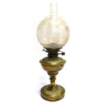 AN EDWARDIAN BRASS OIL LAMP with etched glass shade, 58cm high