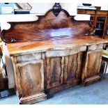 A LARGE VICTORIAN FIGURED MAHOGANY SIDEBOARD with carved back and shaped and inverted breakfront