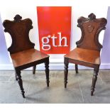 A PAIR OF MAHOGANY HALL CHAIRS on turned front supports