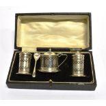 A BOXED THREE PIECE SILVER CONDIMENT SET of lighthouse form with pierced decoration, the mustard pot