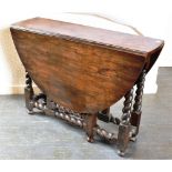 AN OAK GATELEG TABLE on barley twist stretcher base, the oval top 136cm wide (with both leaves),